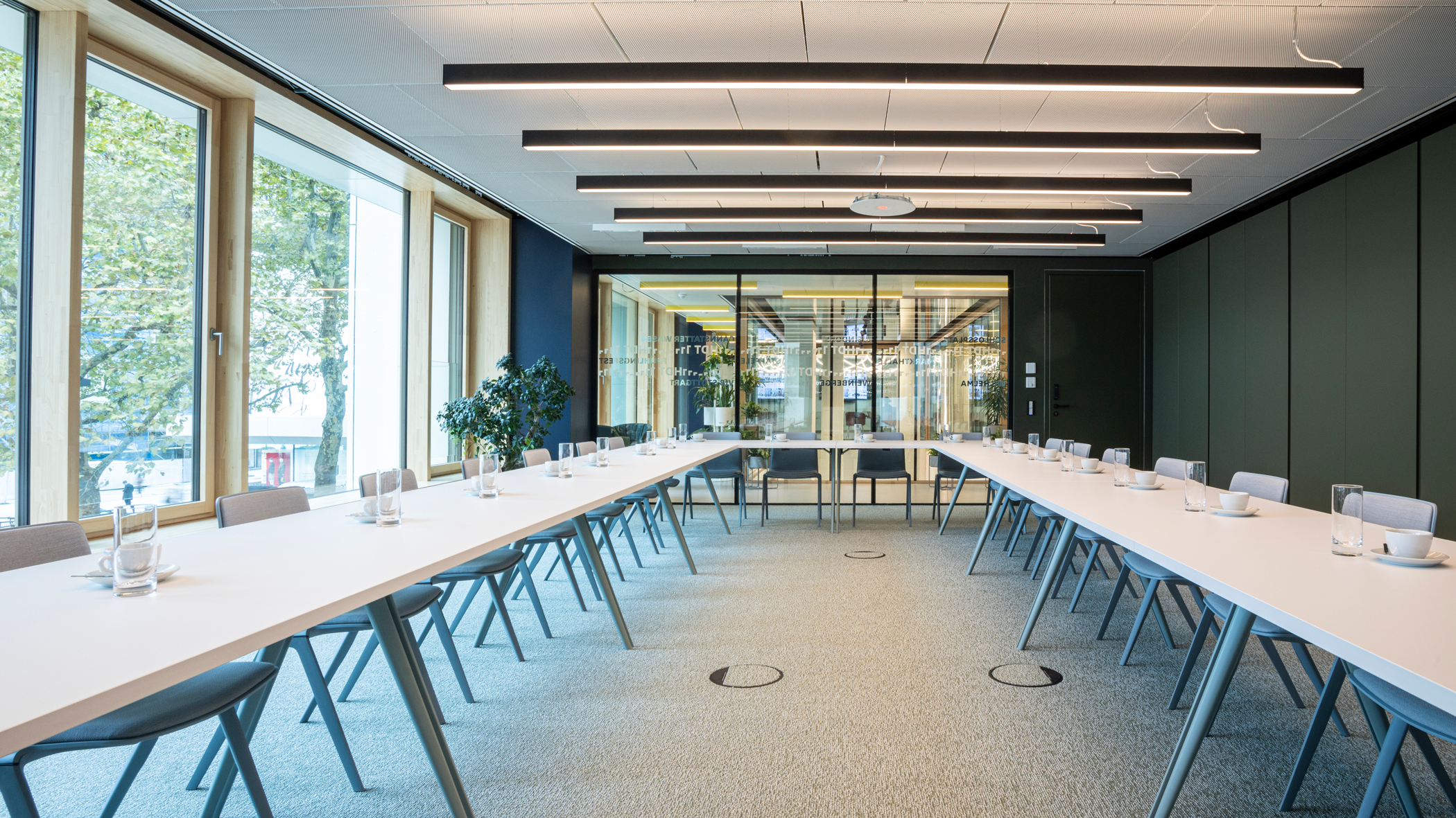 Raum Erlebnis, Stuttgart-Marketing GmbH, Sarah Schmid Großer Konferenzrau mit in U-Form aufgestellten Tischen. Kaffeetasse und Wasserglas an jedem Platz.